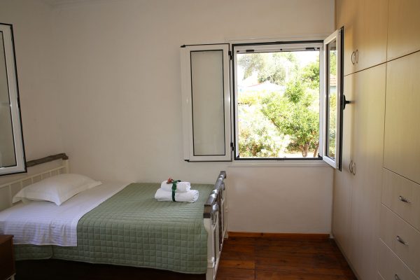 Hidden Gem Kefalonia (House Rental) a bedroom with a bed and a window