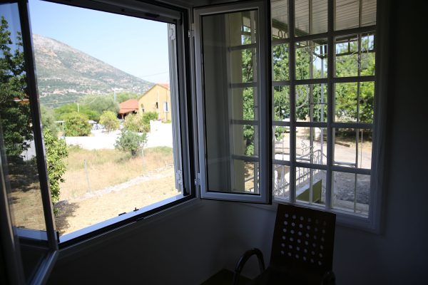 Hidden Gem Kefalonia (House Rental) a chair sitting in front of a window