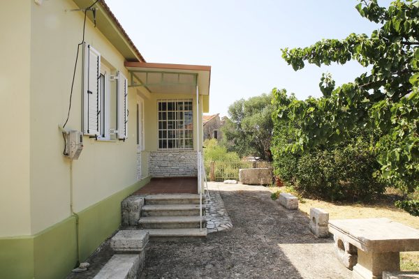 Hidden Gem Kefalonia (House Rental) a house with a stone pathway leading to the front door