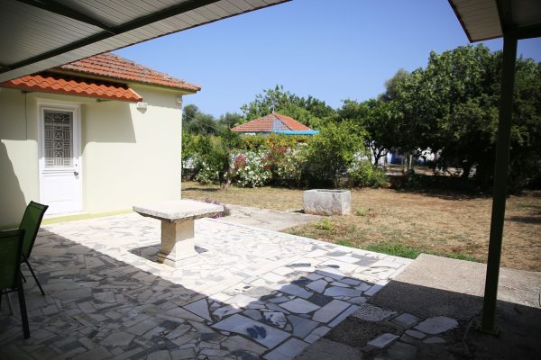 Hidden Gem Kefalonia (House Rental) a patio with a table and chairs in it