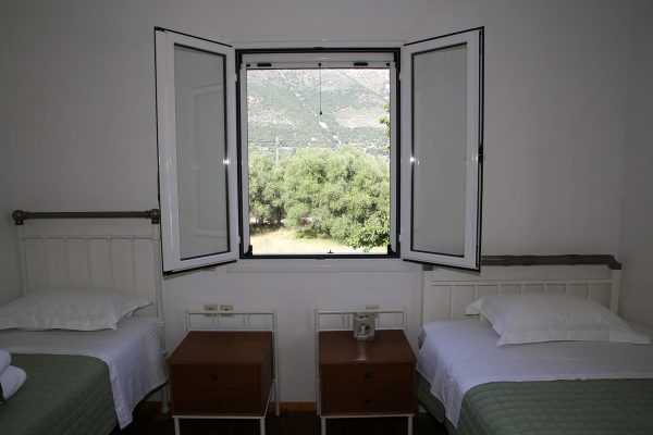Hidden Gem Kefalonia (House Rental) two beds in a room with a window